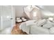 Bright bedroom with a slanted ceiling and access door, wood floors and headboard, and sitting area at 1724 W 40Th Ave, Denver, CO 80211