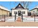 Charming home featuring a black fence, complemented by a black-and-white exterior paint scheme at 1724 W 40Th Ave, Denver, CO 80211