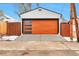 View of the detached garage with a modern door and snow lightly covering the ground at 1724 W 40Th Ave, Denver, CO 80211