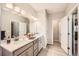 Bathroom features double sinks, granite countertops, framed mirror and wood-look tile flooring at 4051 Happy Hollow Dr, Castle Rock, CO 80104