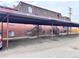 Covered parking area with brick building in background at 5491 E Warren Ave # 217, Denver, CO 80222