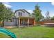 Backyard with a covered patio, outdoor seating, trampoline and a well-manicured lawn at 4333 E Bennington Ave, Castle Rock, CO 80104