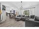 Open-concept living room features a gray sectional sofa, wood flooring, and abundant natural light at 4333 E Bennington Ave, Castle Rock, CO 80104