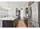 Modern kitchen with island, stainless steel appliances, and white cabinets at 10350 E 57Th Pl, Denver, CO 80238