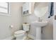 Modern powder room with pedestal sink, toilet and storage at 10350 E 57Th Pl, Denver, CO 80238