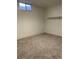 Clean basement with carpeting, small window, and a built-in shelving unit at 16289 E Wagontrail Dr, Aurora, CO 80015