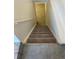 Carpeted staircase leading down to a lower level with tiled landing at 16289 E Wagontrail Dr, Aurora, CO 80015