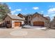 An elegant stone home featuring a circular driveway and multiple garages provides a striking curb appeal at 651 Ruby Trust Dr, Castle Rock, CO 80108