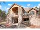 Beautiful exterior elevation of a stone and stucco home, featuring a covered patio and surrounding greenery at 651 Ruby Trust Dr, Castle Rock, CO 80108