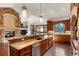 Kitchen with custom wood cabinets, breakfast bar, stainless steel appliances, and stone fireplace at 651 Ruby Trust Dr, Castle Rock, CO 80108