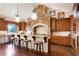 Eat-in kitchen featuring custom wood cabinetry, island with seating, and stone accent wall at 651 Ruby Trust Dr, Castle Rock, CO 80108