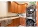 Well-organized laundry room with built-in cabinets, sink, and stacked washer/dryer at 651 Ruby Trust Dr, Castle Rock, CO 80108