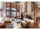 Bright, airy living room featuring a stone fireplace, floor-to-ceiling windows, and hardwood floors at 651 Ruby Trust Dr, Castle Rock, CO 80108