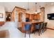 Basement wet bar with barstool seating, wooden cabinetry, and decorative stone archway at 651 Ruby Trust Dr, Castle Rock, CO 80108