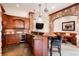 Basement wet bar with stone arches, wine fridge, prep sink, and dining table at 651 Ruby Trust Dr, Castle Rock, CO 80108