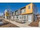 Modern townhome features gray and yellow accents, clean landscaping, and a welcoming entrance at 15276 W 69Th Pl, Arvada, CO 80007