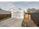The detached garage is painted white and has a concrete driveway with an adjacent entrance to the backyard at 2461 Depew St, Edgewater, CO 80214