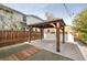 Outdoor patio featuring a wood pergola, manicured lawn, modern home, and wood accents at 2461 Depew St, Edgewater, CO 80214