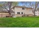 Spacious backyard with lush lawn, mature trees, and partial view of the home's exterior at 9195 E Lehigh Ave # 162, Denver, CO 80237