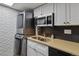 Contemporary kitchen featuring stainless steel appliances, white cabinets, and convenient laundry setup at 9195 E Lehigh Ave # 162, Denver, CO 80237
