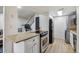 Open kitchen with stainless steel appliances and barstool seating; views to the kitchen and living room at 9195 E Lehigh Ave # 162, Denver, CO 80237
