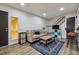 Cozy living room featuring a comfortable sofa, stylish rug, and staircase leading to upper level at 9195 E Lehigh Ave # 162, Denver, CO 80237