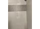 Tiled shower with a modern design, accented by a horizontal band of smaller round decorative tiling at 9195 E Lehigh Ave # 162, Denver, CO 80237