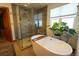 Bright bathroom featuring a large soaking tub, glass-enclosed shower, and modern fixtures at 4765 Larksong Dr, Castle Rock, CO 80109