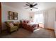 Bright bedroom features soft carpet, wood trim, natural light, and a comfortable sitting chair at 4765 Larksong Dr, Castle Rock, CO 80109