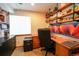 Well-lit home office with custom shelving, a spacious desk, and modern dual monitors at 4765 Larksong Dr, Castle Rock, CO 80109