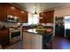 Well-equipped kitchen with wood cabinets, stainless steel appliances, and dark countertops at 4765 Larksong Dr, Castle Rock, CO 80109