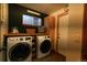 Functional laundry room with front-load washer and dryer, and built in shelves at 4765 Larksong Dr, Castle Rock, CO 80109