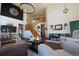 Elegant living room featuring a modern chandelier, staircase, and stylish decor at 4765 Larksong Dr, Castle Rock, CO 80109