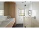 Modern bathroom with white marble countertop, wooden vanity, and glass enclosed shower at 5800 E 6Th Avenue Pkwy, Denver, CO 80220