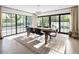 Bright dining room with large windows and doors, modern chandelier, and stylish wood table with seating for six at 5800 E 6Th Avenue Pkwy, Denver, CO 80220