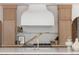 Modern kitchen with marble backsplash, custom hood, and gourmet features at 5800 E 6Th Avenue Pkwy, Denver, CO 80220
