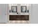 Bathroom featuring a dual sink vanity with framed mirrors and modern lighting at 481 Meadowleaf Ln, Highlands Ranch, CO 80126