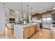 Open-concept kitchen with a large island, stainless steel appliances, and a view into the living room and fireplace at 481 Meadowleaf Ln, Highlands Ranch, CO 80126