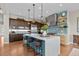 Modern kitchen with large island, barstools, stainless appliances, and decorative backsplash at 481 Meadowleaf Ln, Highlands Ranch, CO 80126