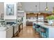 Open-concept living area with modern fireplace and adjoining kitchen island with stool seating at 481 Meadowleaf Ln, Highlands Ranch, CO 80126
