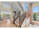 Modern staircase with metal railings, wood accents, and large windows providing ample natural light into the open-concept home at 481 Meadowleaf Ln, Highlands Ranch, CO 80126