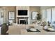Open-concept living room with modern fireplace and neutral tones, adjacent to the dining area at 16500 Black Rose Cir, Parker, CO 80134