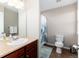 Cozy bathroom featuring a single vanity, toilet, and a shower with a patterned curtain at 35 N Newcastle Ct, Aurora, CO 80018