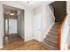 Bright foyer featuring hardwood floors, staircase with wooden banister, coat closet and entry way to the rest of the home at 35 N Newcastle Ct, Aurora, CO 80018