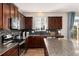 Modern kitchen with dark wood cabinets, a granite island, and stainless steel appliances at 35 N Newcastle Ct, Aurora, CO 80018
