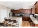 Kitchen with an island, stainless steel appliances, dark wood cabinets, and granite countertops at 35 N Newcastle Ct, Aurora, CO 80018