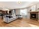 Open-concept living room with hardwood floors, fireplace, and comfortable sectional, perfect for Gathering gatherings at 35 N Newcastle Ct, Aurora, CO 80018