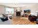 Cozy living room featuring a fireplace, hardwood floors, large windows, and comfortable seating for relaxation and entertaining at 35 N Newcastle Ct, Aurora, CO 80018