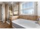 A closeup of the bathtub, tilework, and glass enclosed shower at 35 N Newcastle Ct, Aurora, CO 80018