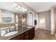 A detailed view of the bathroom featuring a double vanity, mirror, and tiled shower at 35 N Newcastle Ct, Aurora, CO 80018